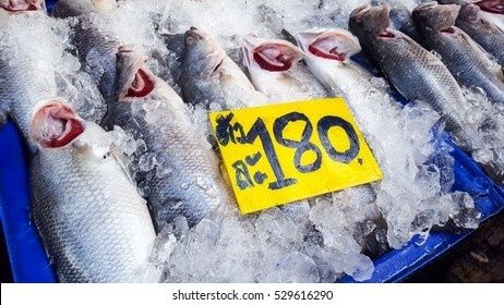 Poissons frais sur glace avec une étiquette jaune indiquant 180